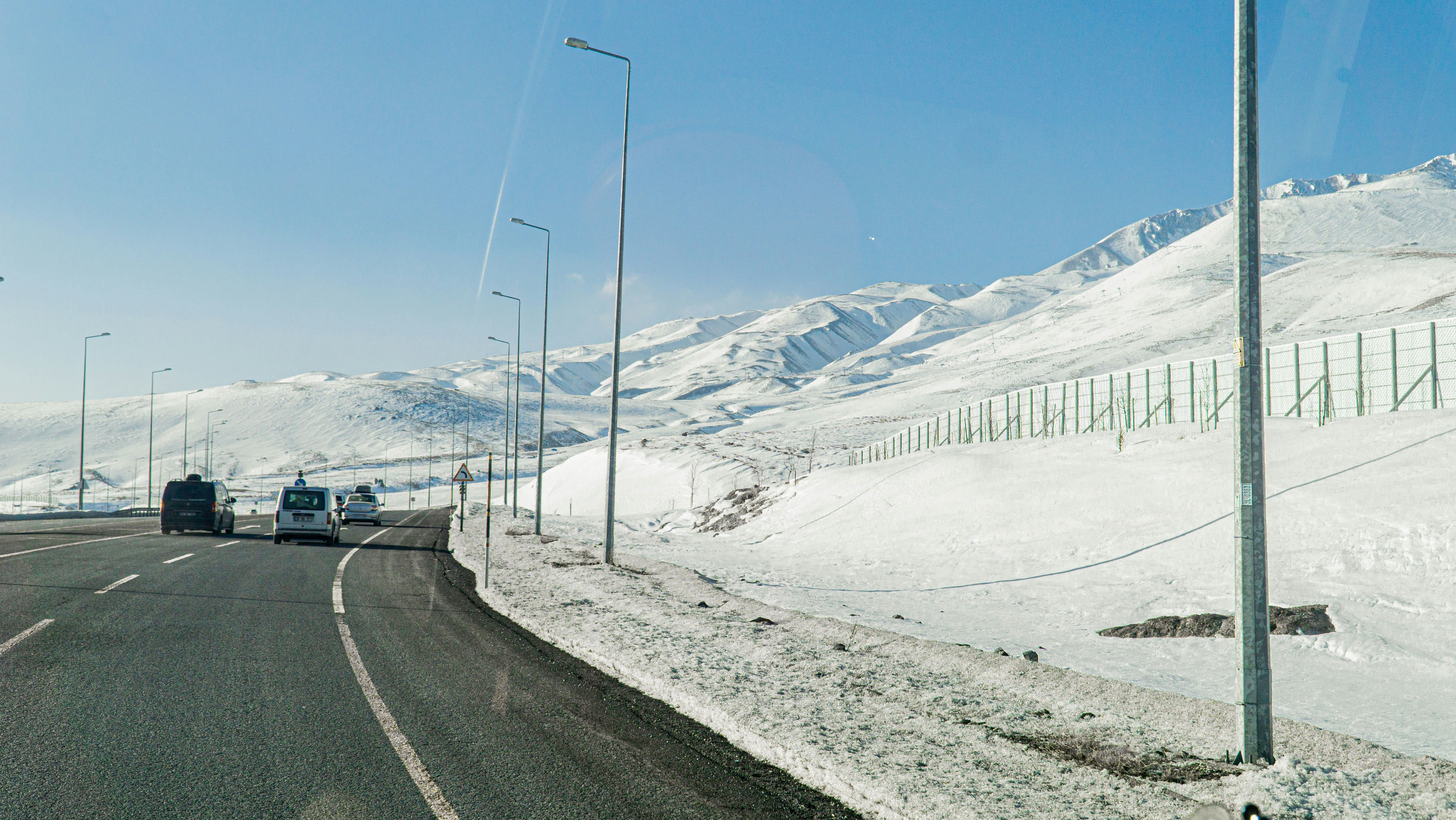 Voiture circulant sur une route de montagne enneigée en hiver