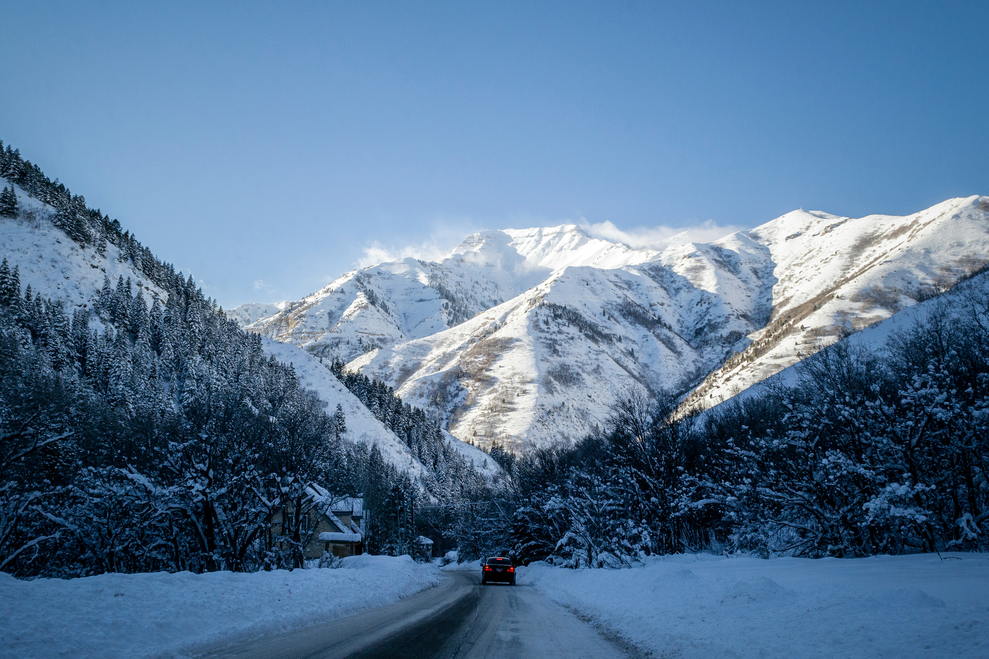 Voiture circulant sur une route de montagne enneigée en hiver